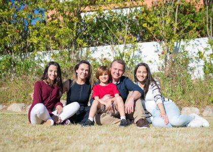 A joyful family enjoying sunny moments in a lush Portuguese garden.